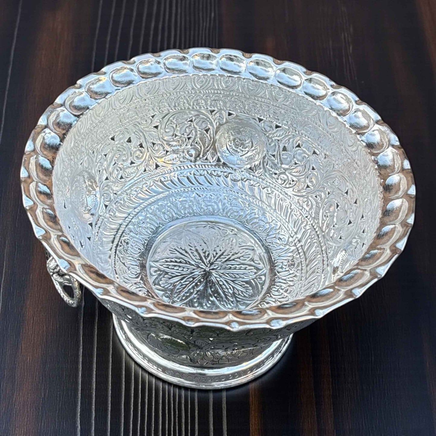Close-up of Tall German silver fruit bowl intricate antique silver pattern reflective surface