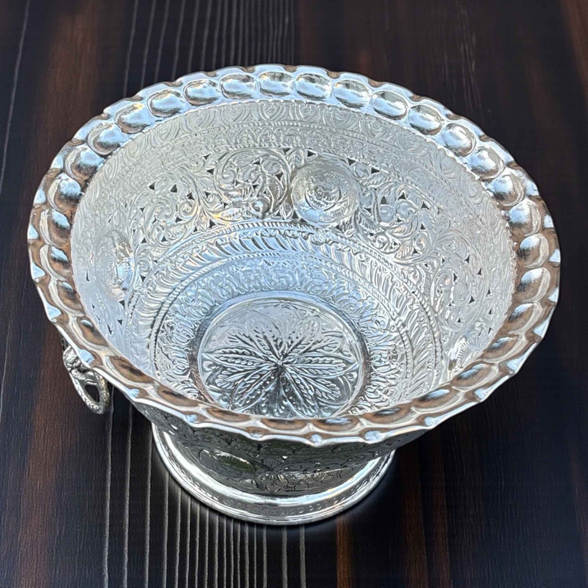 Close-up of Tall German silver fruit bowl intricate antique silver pattern reflective surface