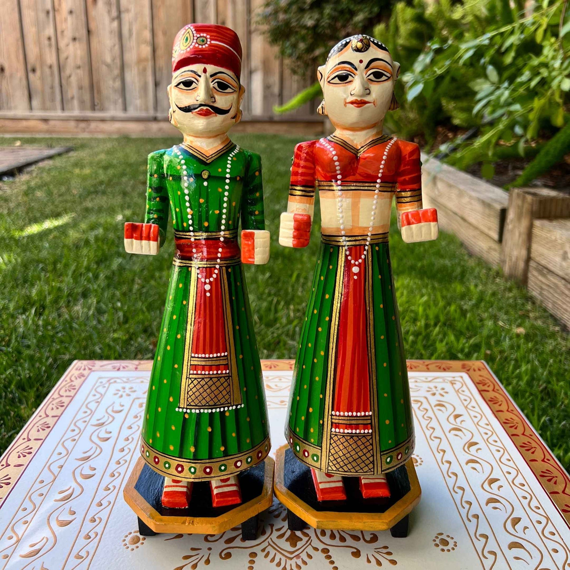 Indian Queen doll from the Isar Gangaur pair, adorned with a orange and green headdress and intricate ethnic dress patterns