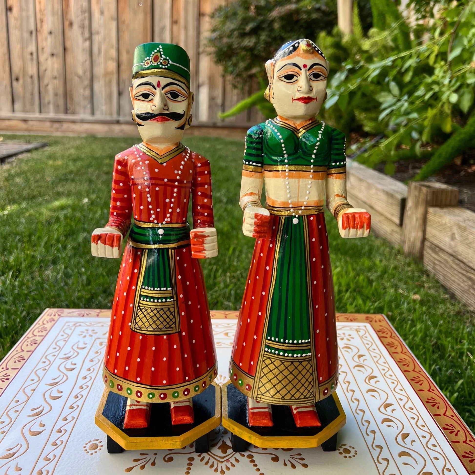 Indian Queen doll from the Isar Gangaur pair, adorned with a orange and green headdress and intricate ethnic dress patterns