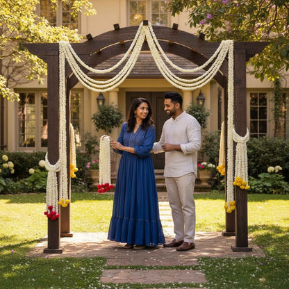 Couple standing under a decorated archway in a garden setting