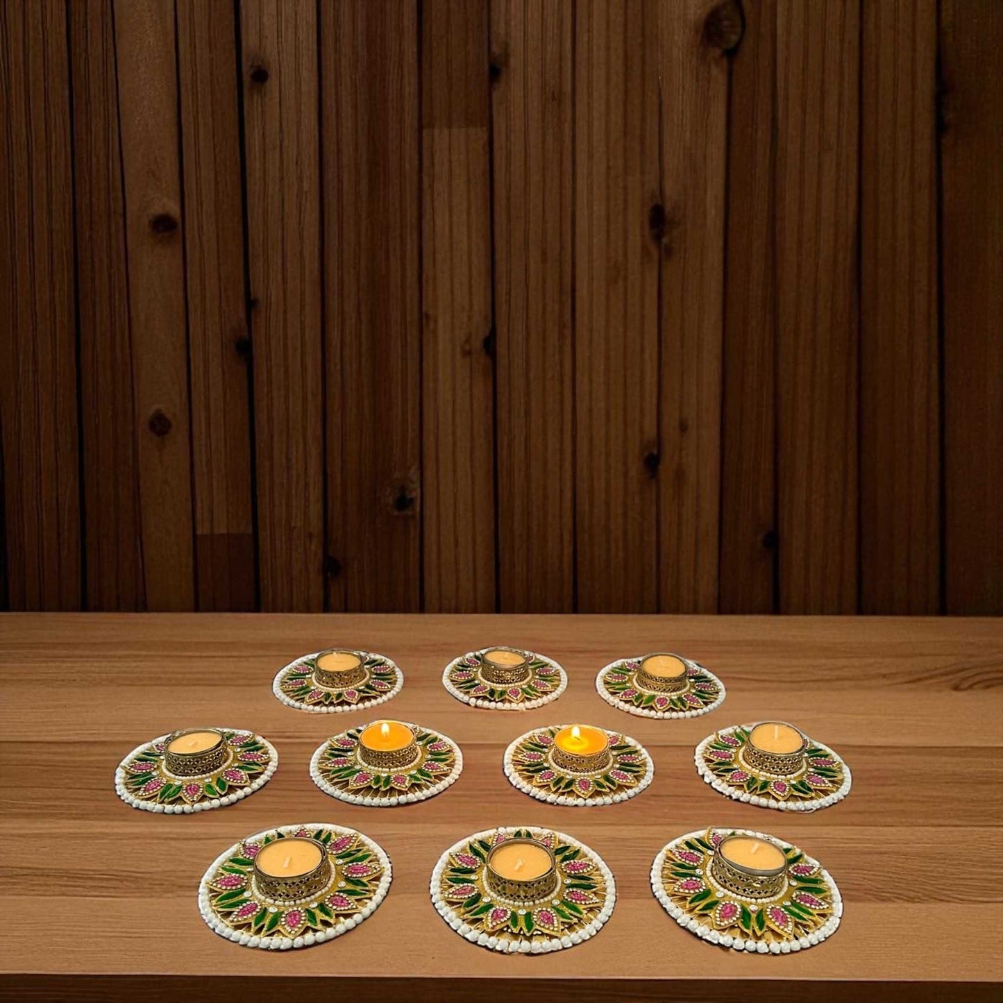 Set of 10 multicolor Diwali T-light holders on wooden table; warm ambiance, pearl border and floral pattern.