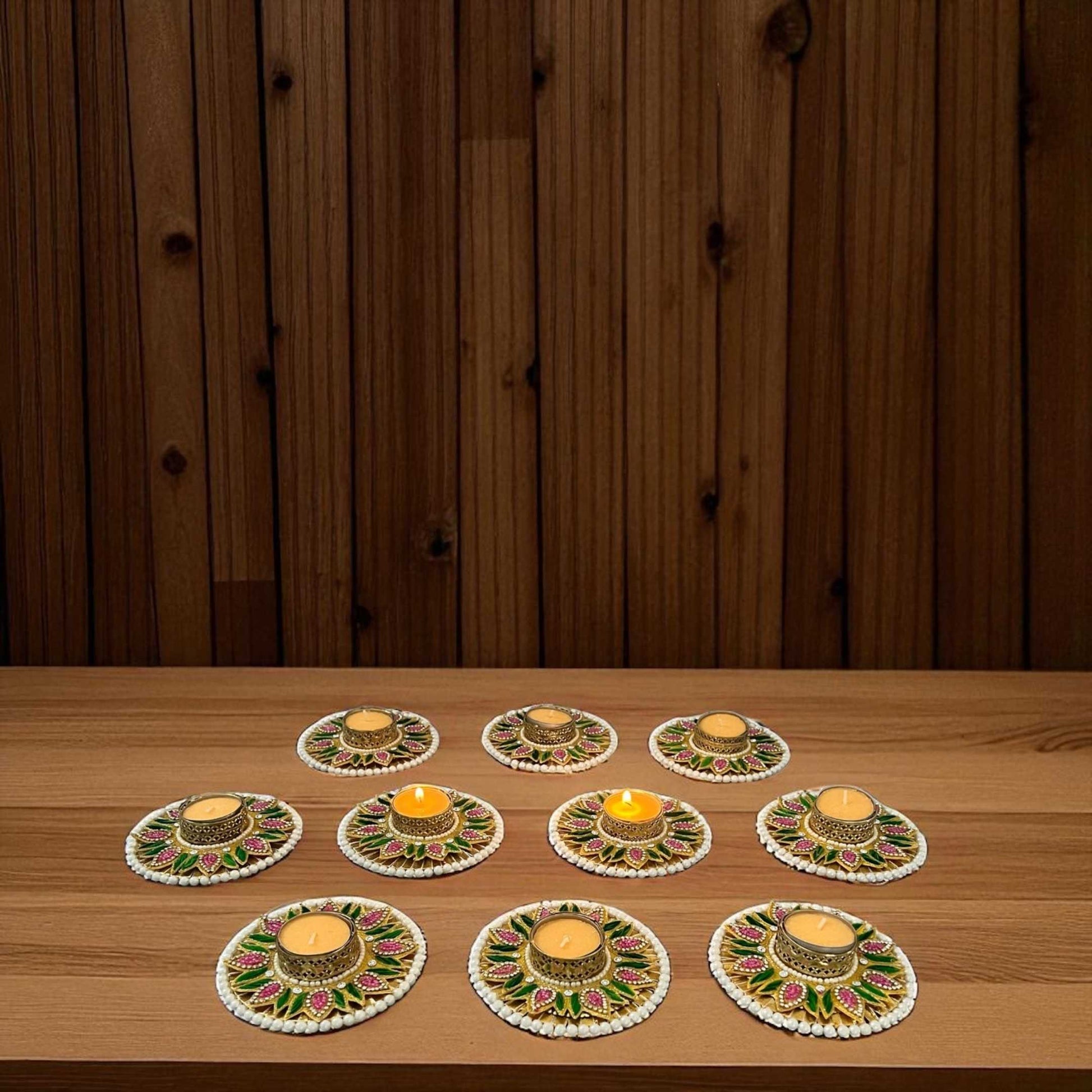 Set of 10 multicolor Diwali T-light holders on wooden table; warm ambiance, pearl border and floral pattern.
