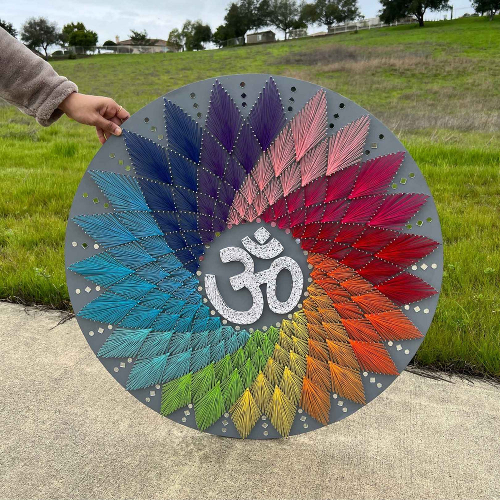 30-inch Om string art in coloured nail and thread, mounted as a wall piece