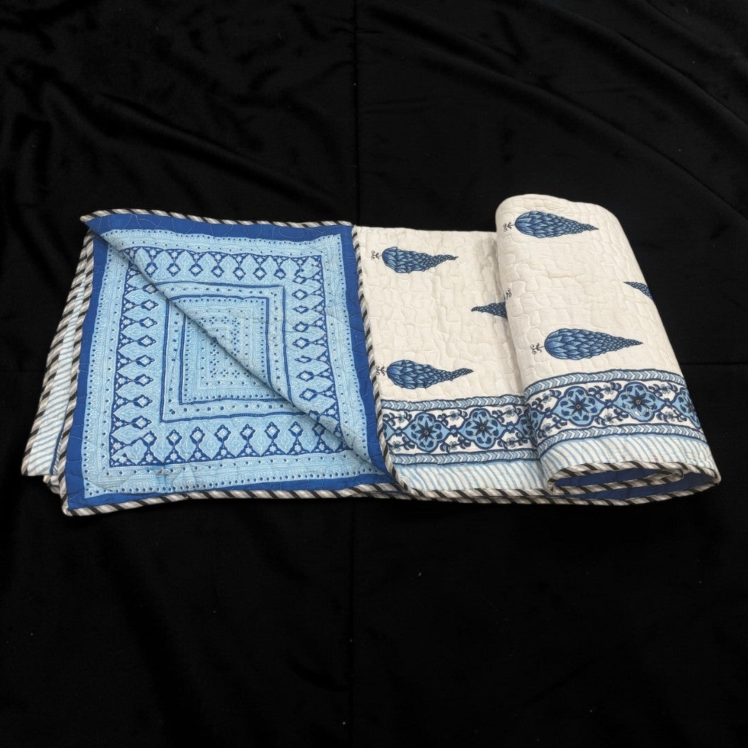 Two folded fabrics with blue and white patterns on a black background