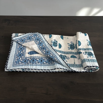 Rolled-up blue and white patterned fabric on a dark wooden surface