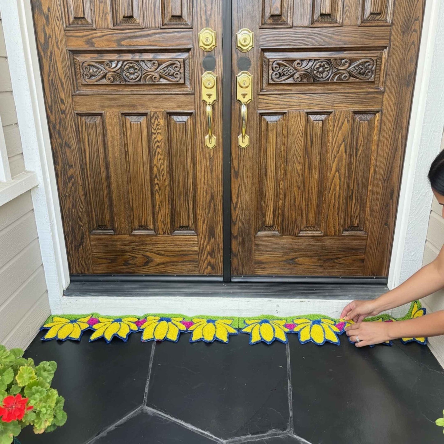 Yellow lotus rangoli mat on wood floor in front of ornate white cabinet Indian decor