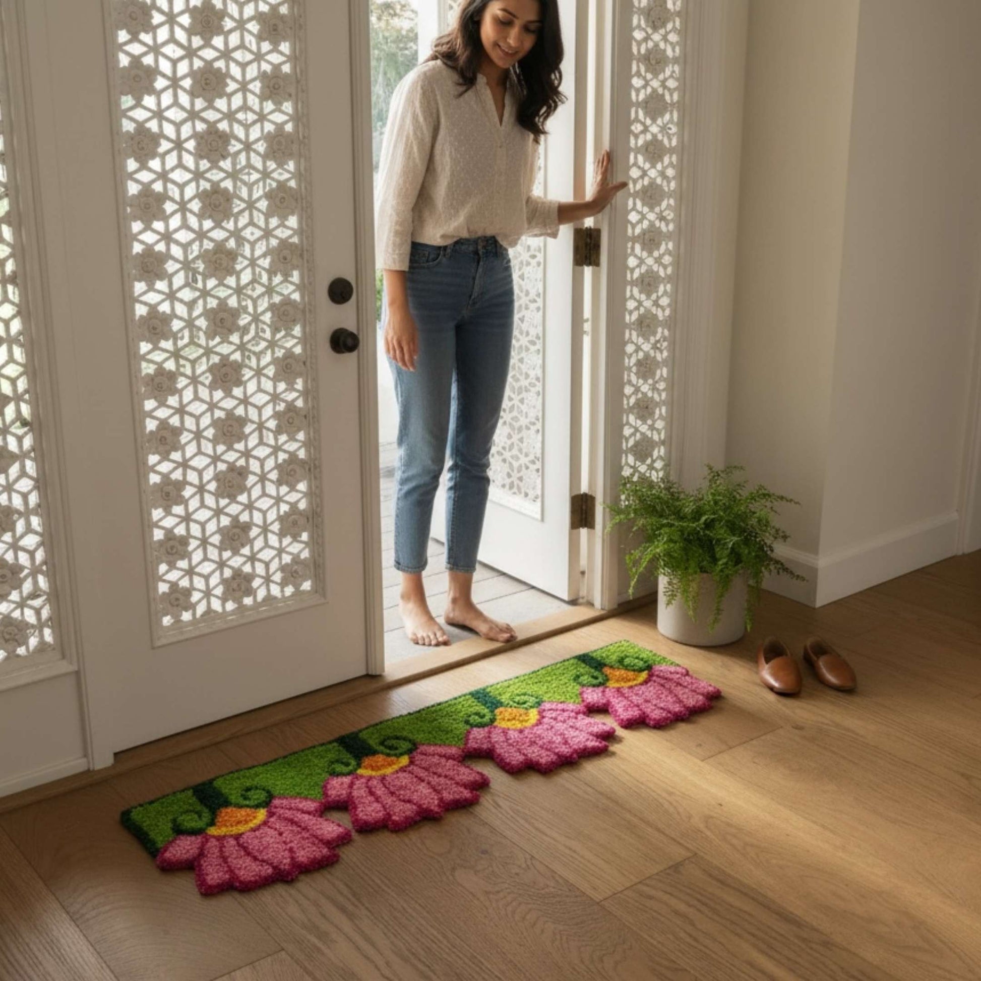 Woman at doorway with pink lotus rangoli mat Indian home entry Diwali housewarming decor