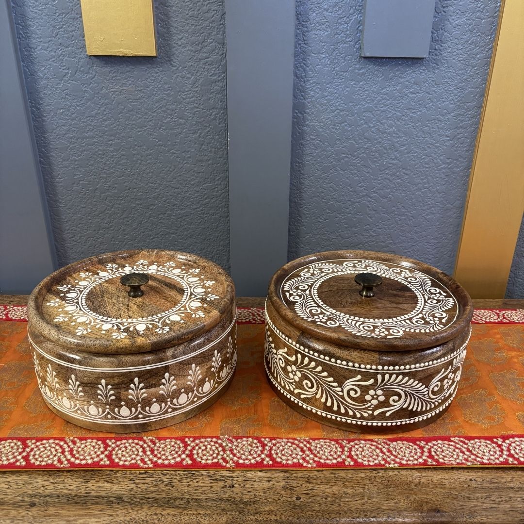 Two handcrafted mango wood roti boxes with floral inlay on red gold Indian table runner