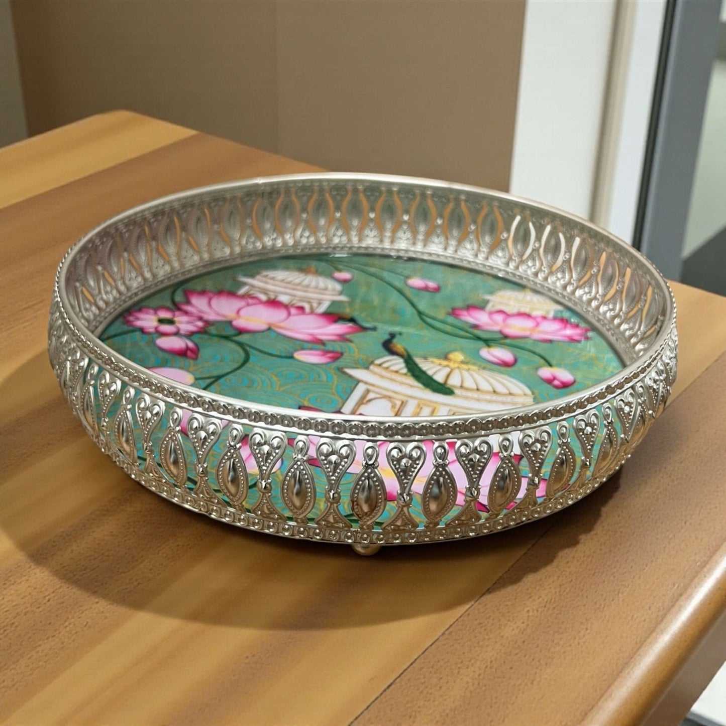 Decorative round tray with floral design on a wooden surface