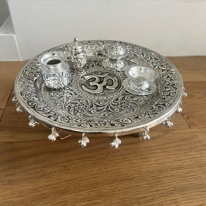 Macro shot of hand-engraved detailing on an antique German silver-plated brass pooja set showing the premium artisan finish.