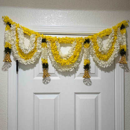 Champa yellow-white marigold toran bandhanwar close-up on white paneled door. 
