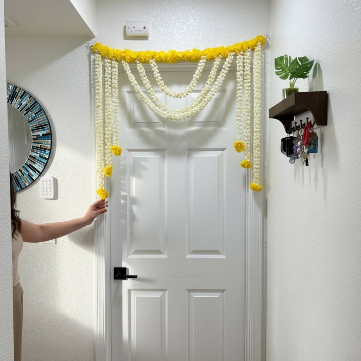 Decorative yellow and white garlands hanging above a white door.