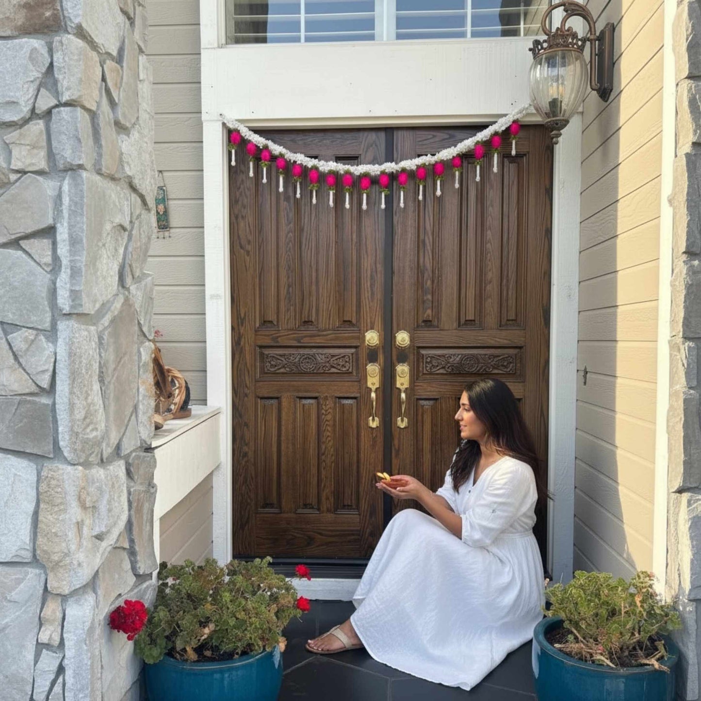 Traditional Indian Jasmine Bandhanwar hanging on a wooden front door for Diwali and housewarming celebration decor.