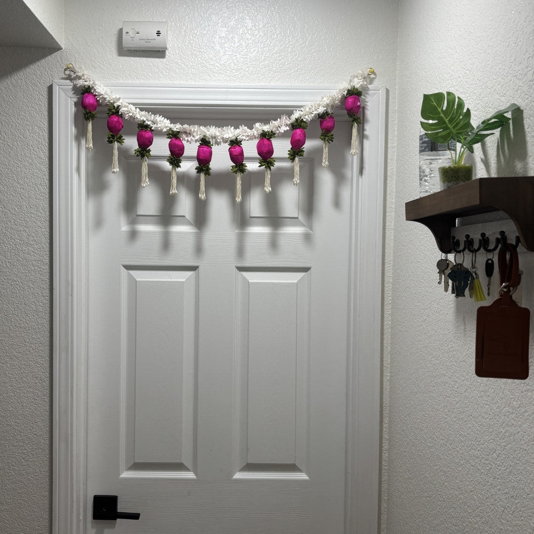 3FT Jasmine & Dark Pink Bud Toran hanging on a wooden front door – handmade Indian Diwali door decoration with white jasmine and sola wood buds