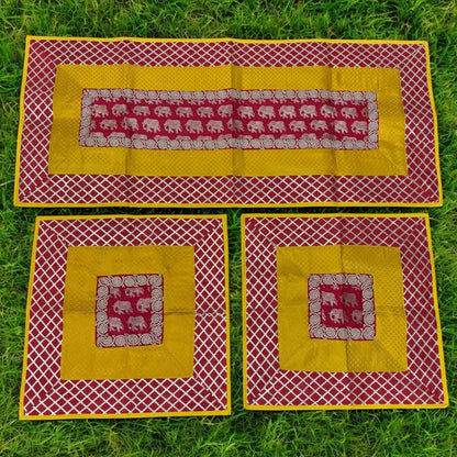 Set of three fabric placemats with elephant pattern on a grass background