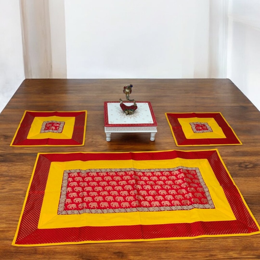 Set of red and yellow patterned placemats on a wooden table with a white background