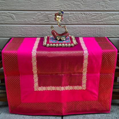 Styled Diwali altar: Pink Zigzag Banarasi brocade pooja aasan with diya and marigold — prayer mat décor