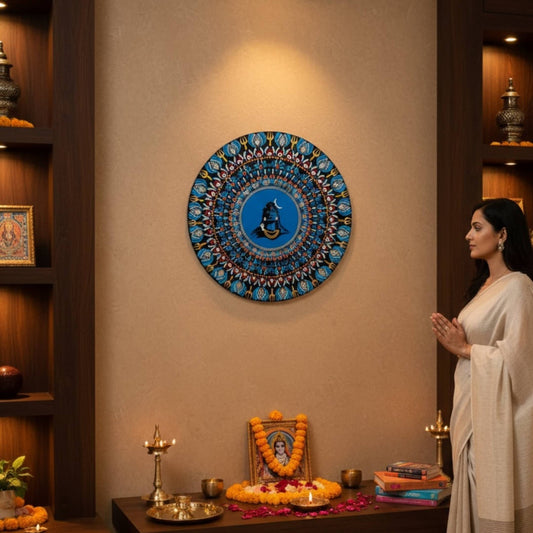 Woman in a white saree standing in front of a decorated altar with a blue adiyogi wall art.