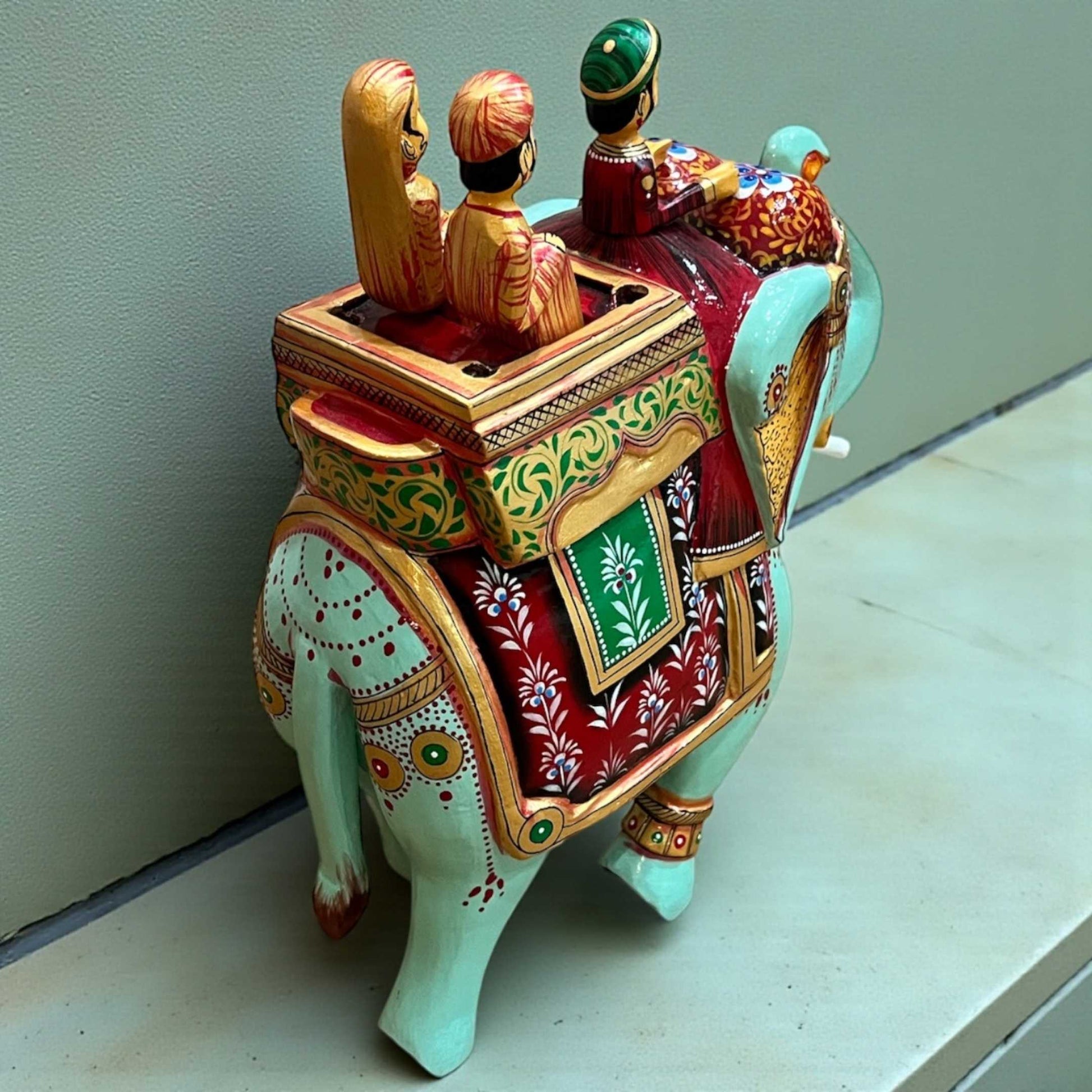 Detailed view of Walking Ambabari Elephant sculpture showing carved human figures riding in an ambari (howdah) on elephant back.