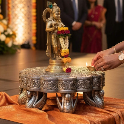 Antique silver pooja chowki used as a pedestal for Hindu deity statues in a home mandir.