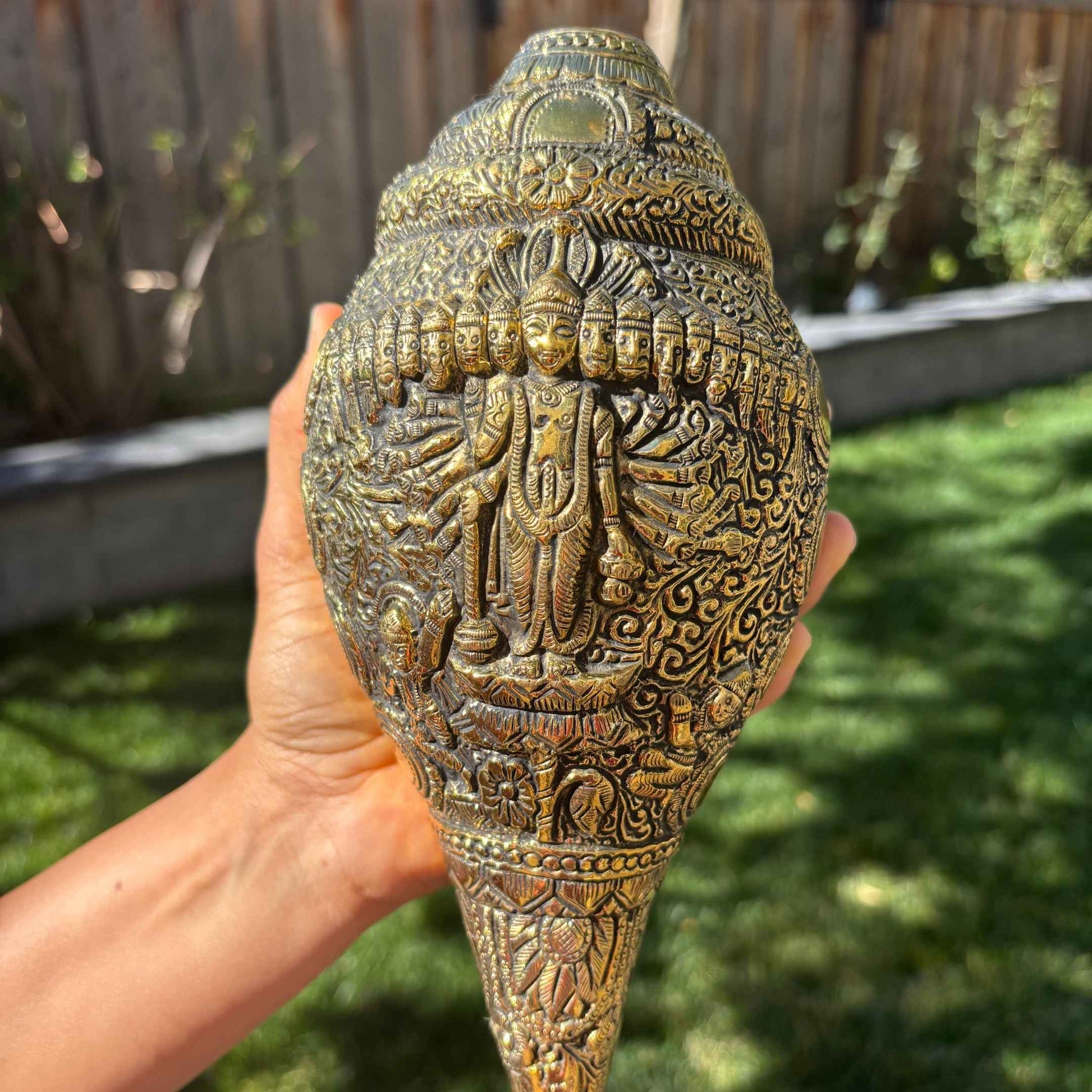 Hand-engraved Dashavatar brass shankh – close-up of Vishnu avatar carvings outdoor