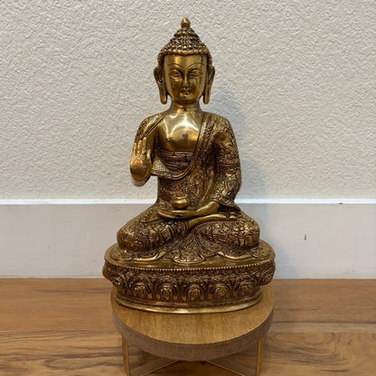 12" Brass Buddha statue on wooden pedestal against white wall — ideal for home temple