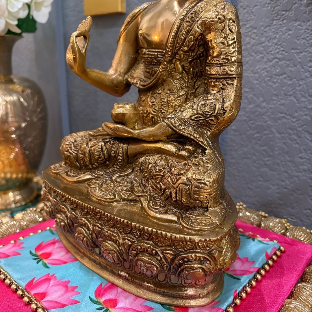 Gold-colored seated Buddha statue on vibrant fabric — spiritual home decor display