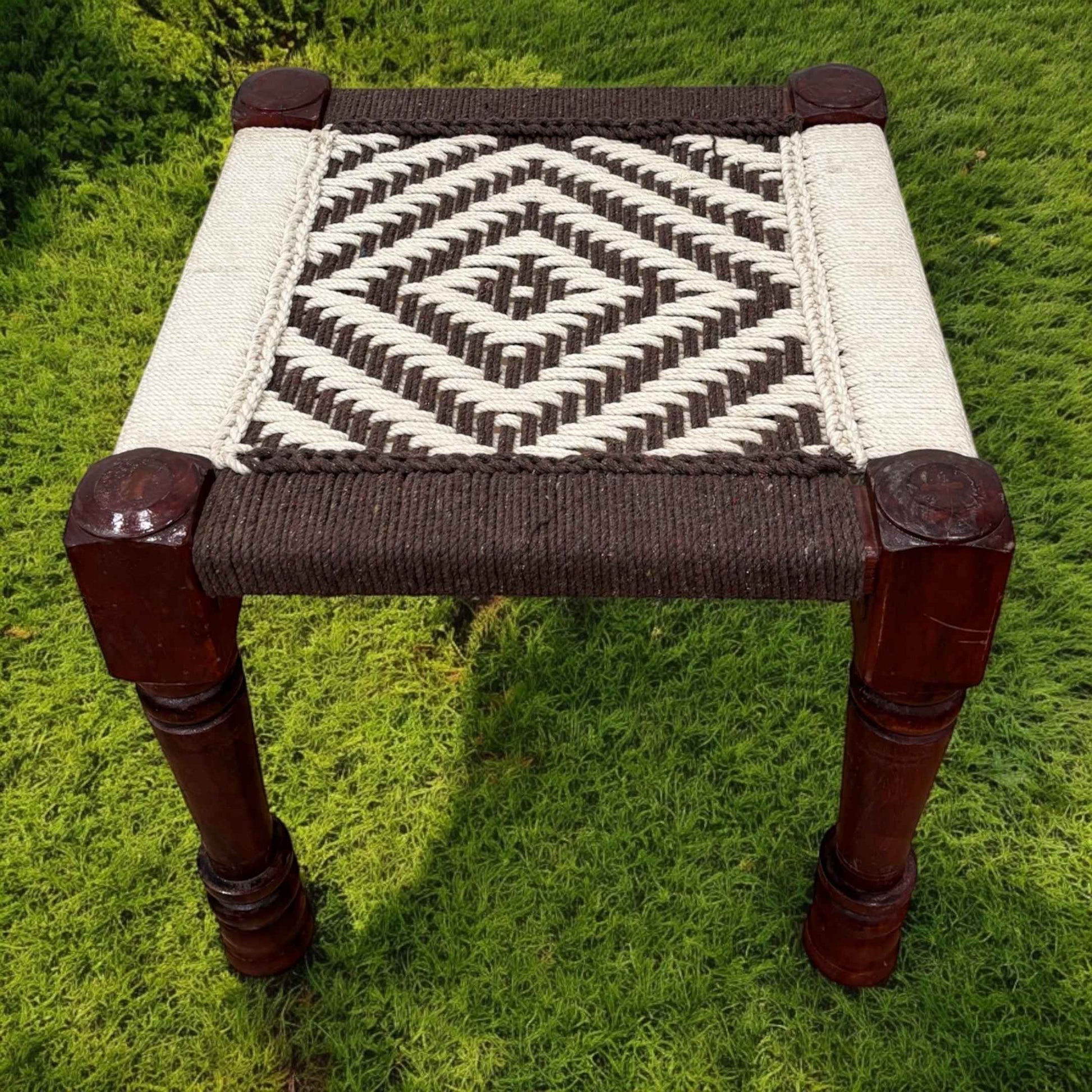 Indian charpai stool in white and brown color featuring a woven rope seat - perfect decor element in backyard sitting