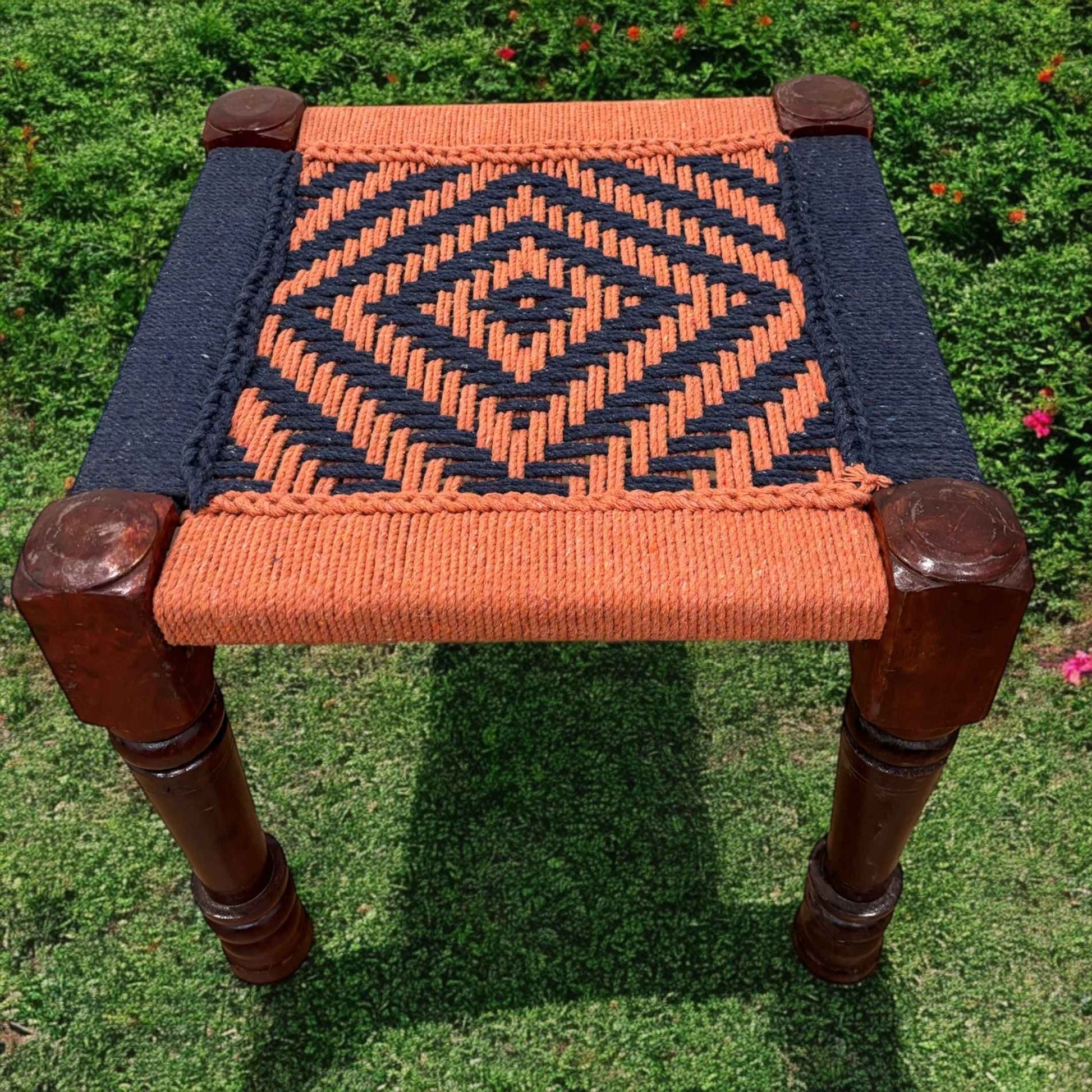 boho dressing vintage in orange and blue color featuring a woven jute rope seat atop a wooden frame with four sturdy legs