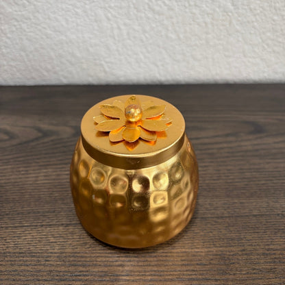 Single copper container with decorative floral lid on wooden table — copper jar close-up