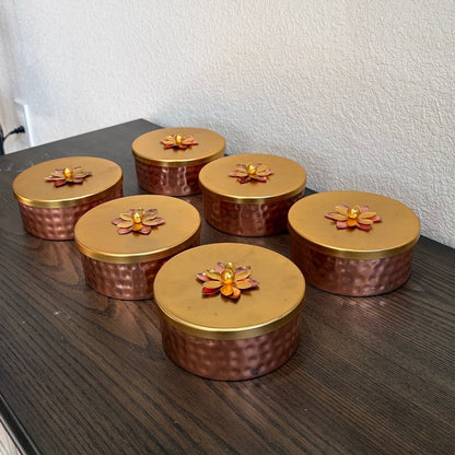 Six decorative copper boxes with floral lids displayed in a row — premium Indian copper box set