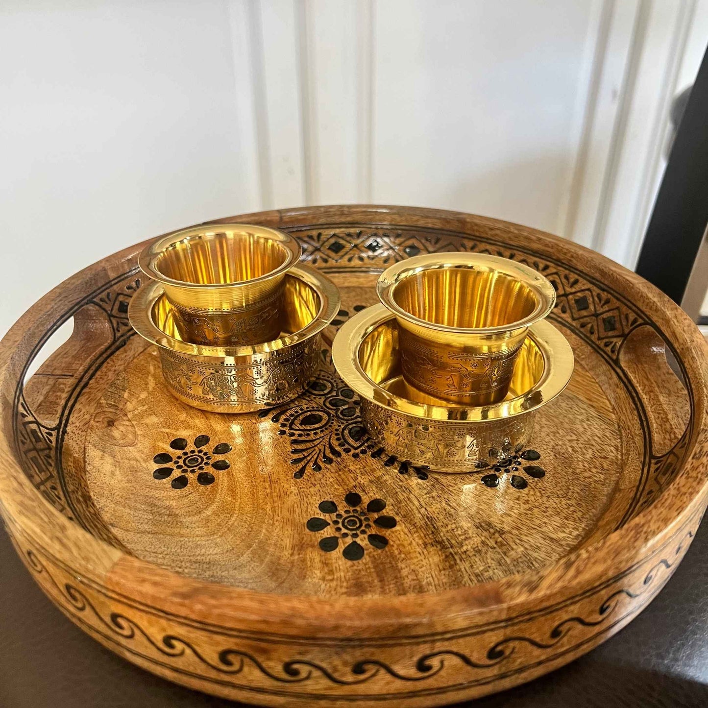 Brass davara tumbler and collector bowl on handcrafted wooden tray with floral carving