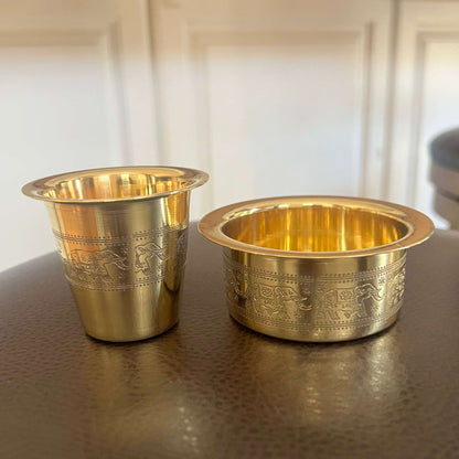 Close-up of brass davara tumbler and collector bowl with engraved elephant motif bands