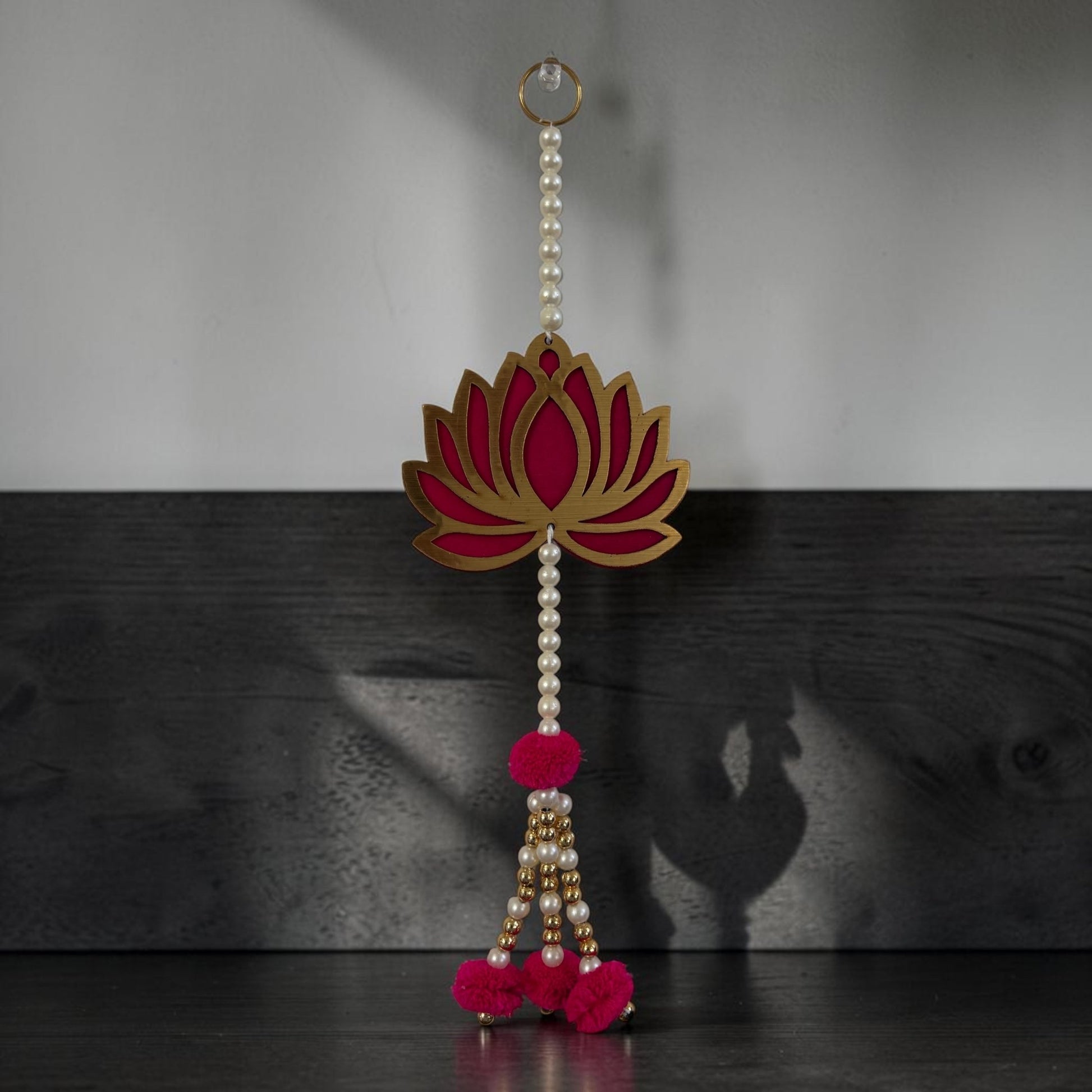 Long lotus dangler with pearl bead string, gold-pink MDF cutout and hot pink pom-pom tassel ends