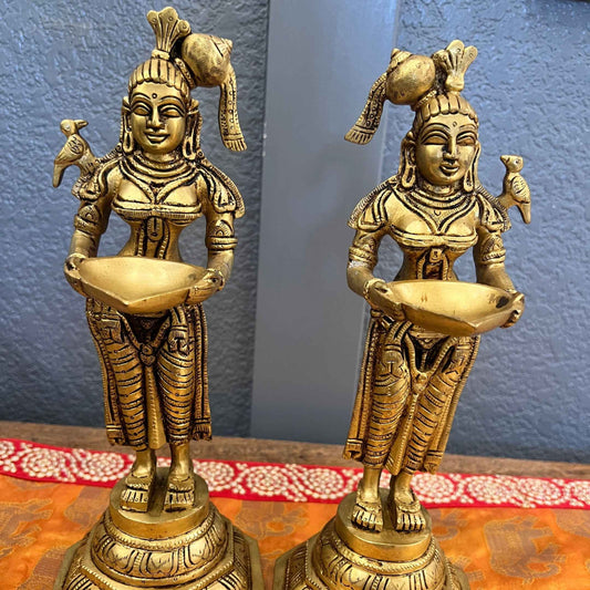 Set of 2 Deep Lakshmi brass oil lamps, a mirrored pair with parrots and conch hair ornaments