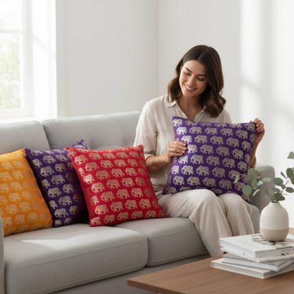 Woman holding a purple pillow with elephant pattern on a gray sofa