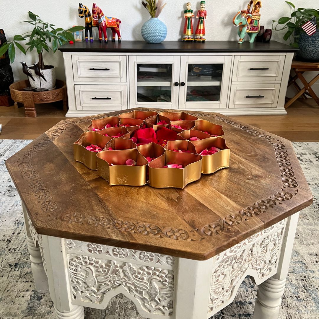 Decorative wooden table with a central floral arrangement in a home setting.