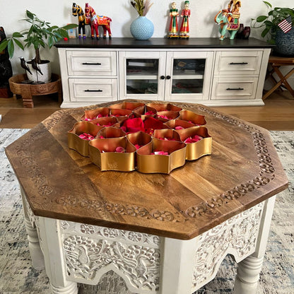 Decorative wooden table with a central floral arrangement in a home setting.