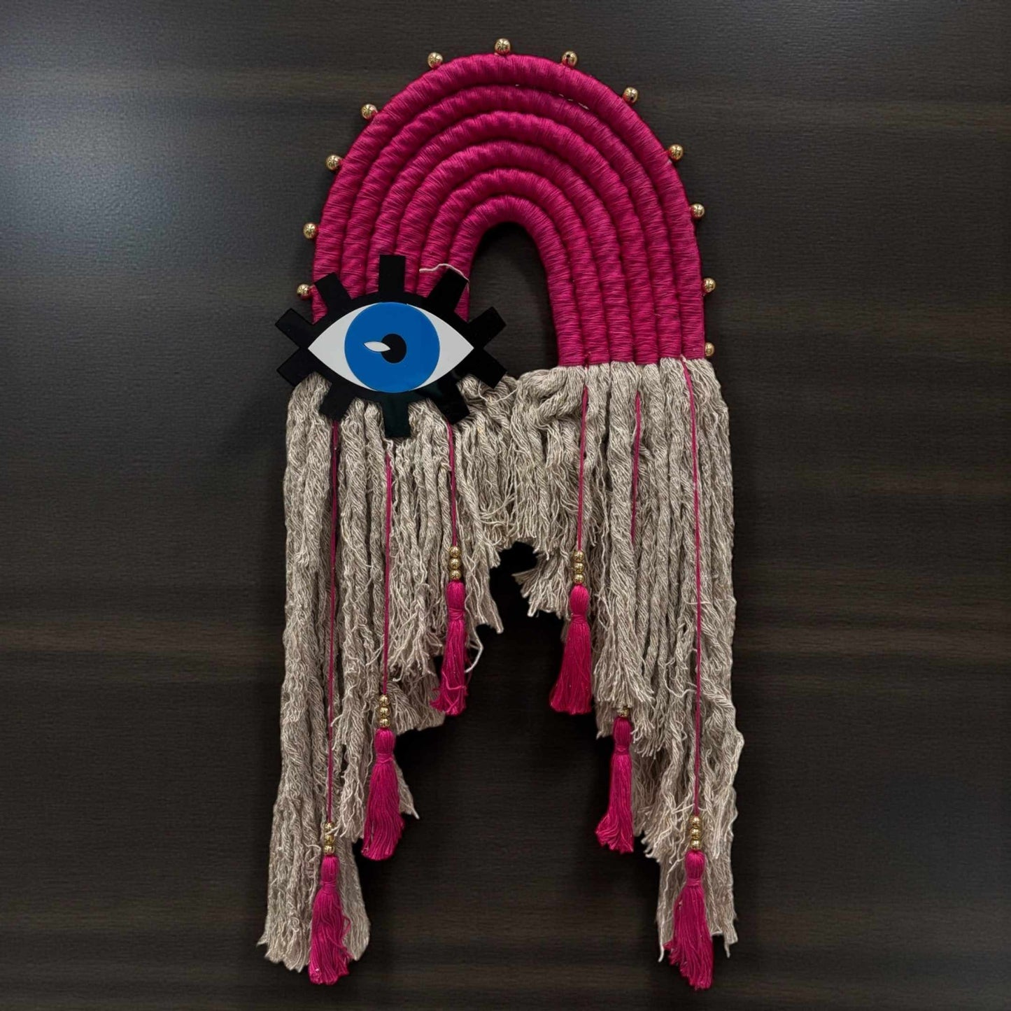 Soft pink boho evil eye decor for nursery or bedroom wall with handmade cotton tassels.