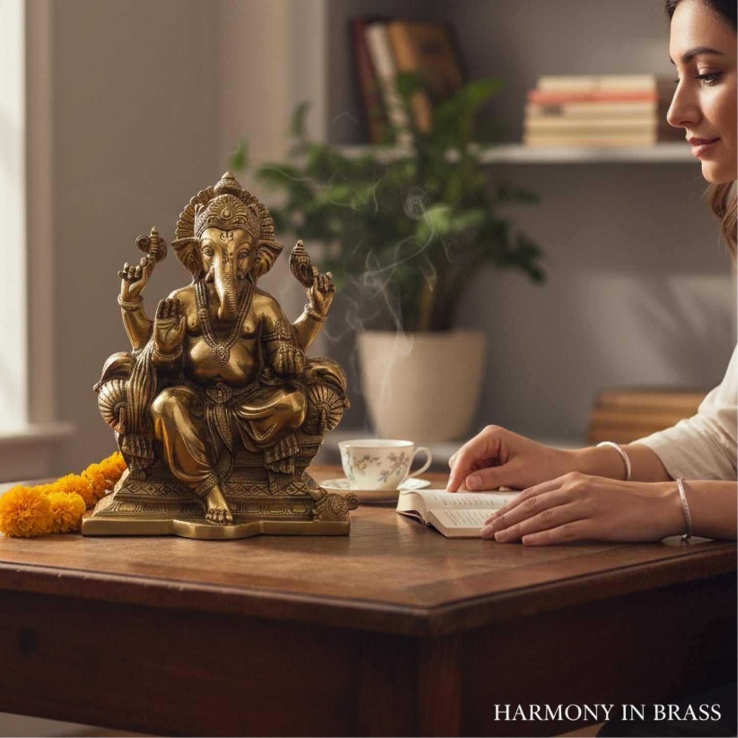 Woman reading beside a brass Ganesha statue on wooden table — meditation and wellness decor idea