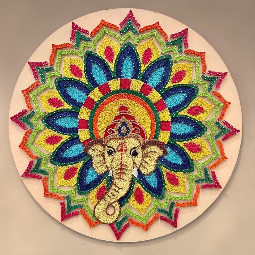 30-inch Ganesha string art wall decor featuring intricate colorful thread work and gold nails on a dark circular MDF board by Urli Utsav.