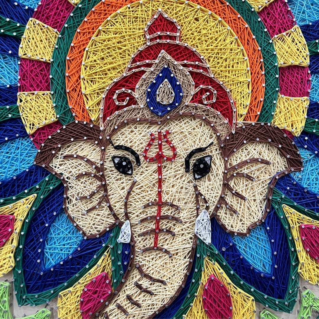 Colorful string art of a deity's face with a circular design in the background