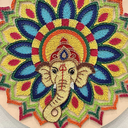 Close-up detail of handmade Ganesha wall hanging showing vibrant multi-colored embroidery threads and meticulous nail placement by artist Ekta Thakur Sharma.