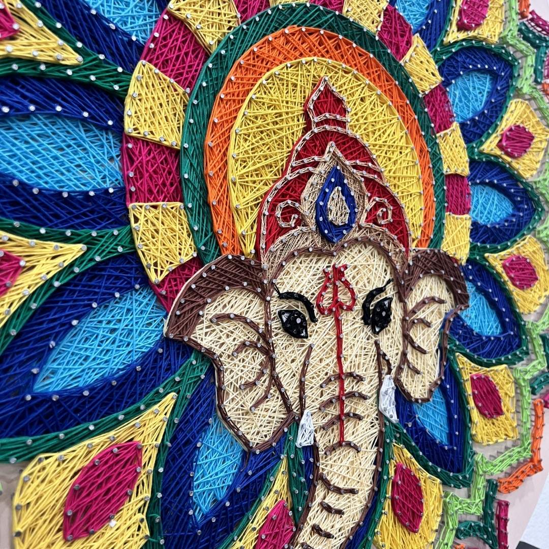 Colorful embroidered design of an elephant with a decorative background