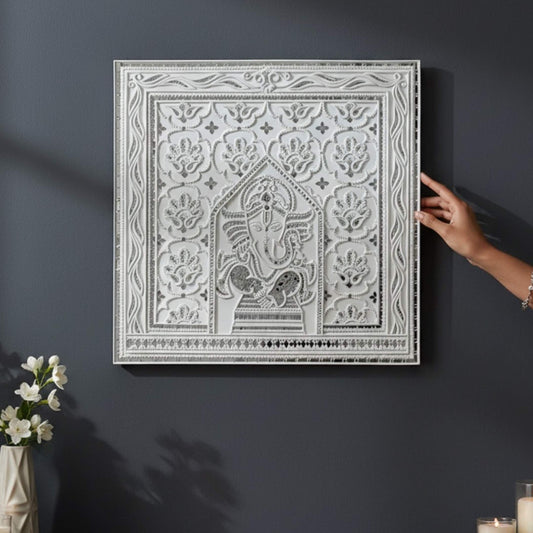 2ft Ganesha White Lippan wall art with intricate patterns on a dark wall, accompanied by a hand and flowers.