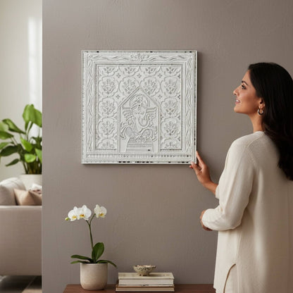 Woman adjusting 2ft Ganesha White Lippan in a living room.