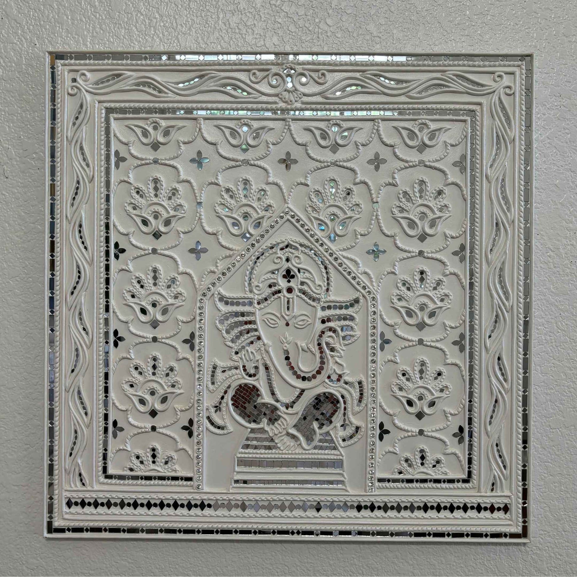 Decorative Ganesha Lippan wall art with intricate design on white wall