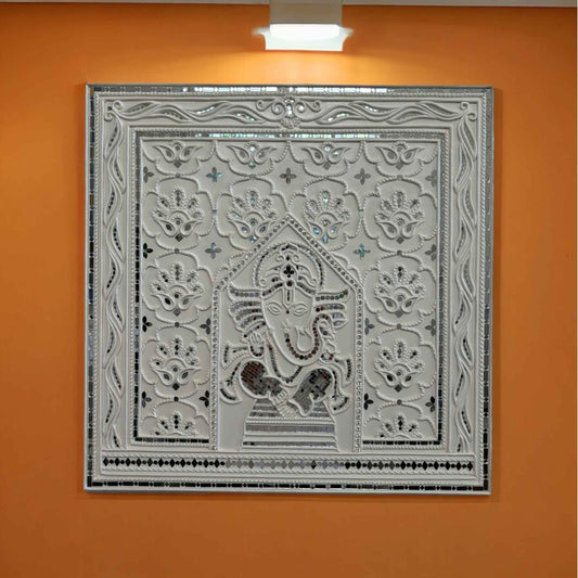 Decorative Ganesha Lippan wall art with intricate design on an orange wall