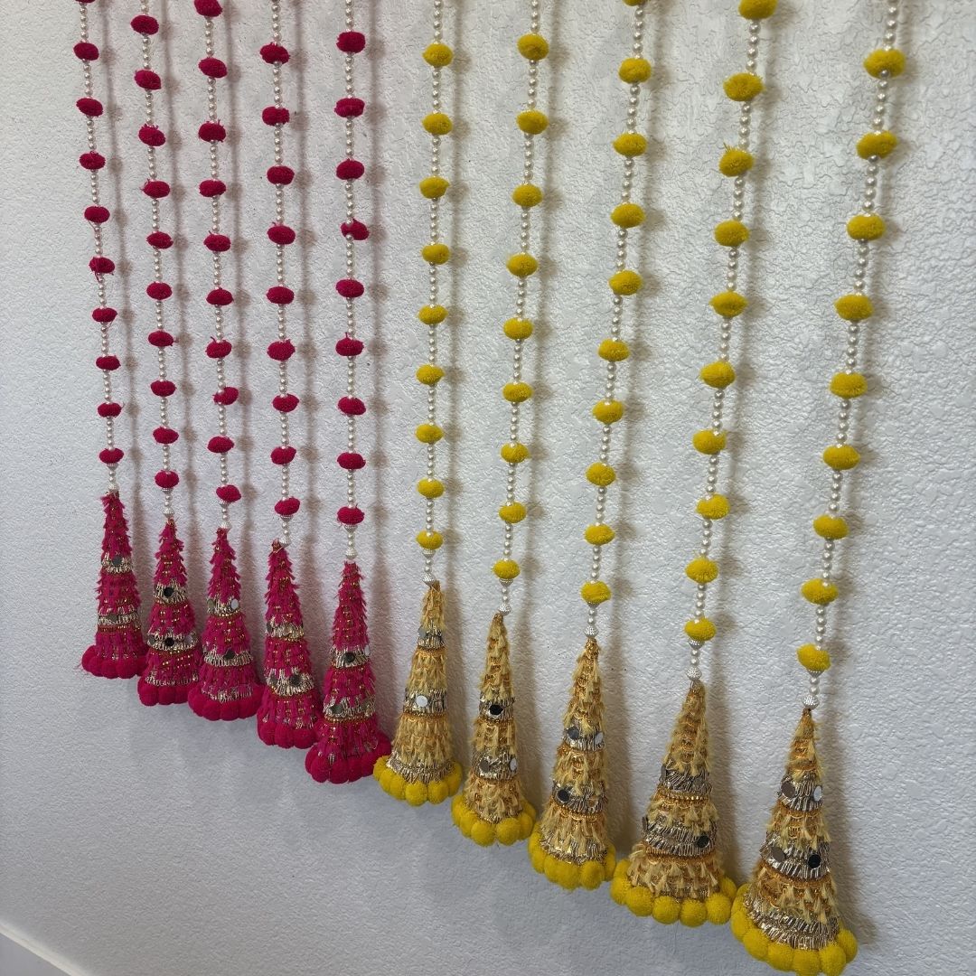 Red and white woolen bead garland on wall – Indian wedding and mehndi backdrop